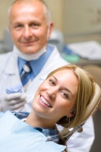 woman smiling with dentist behind her